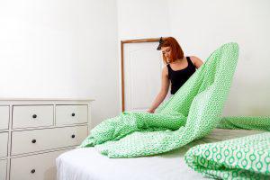 Woman changing bed sheet.