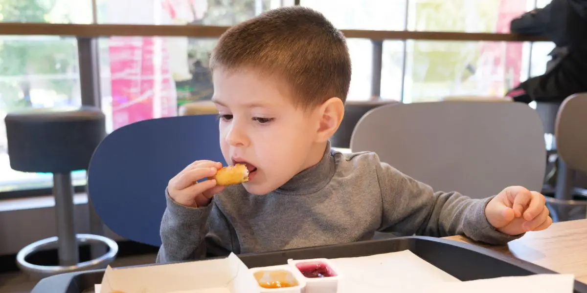 Child eating chicken nuggets.