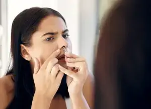 Woman removing nose hair.