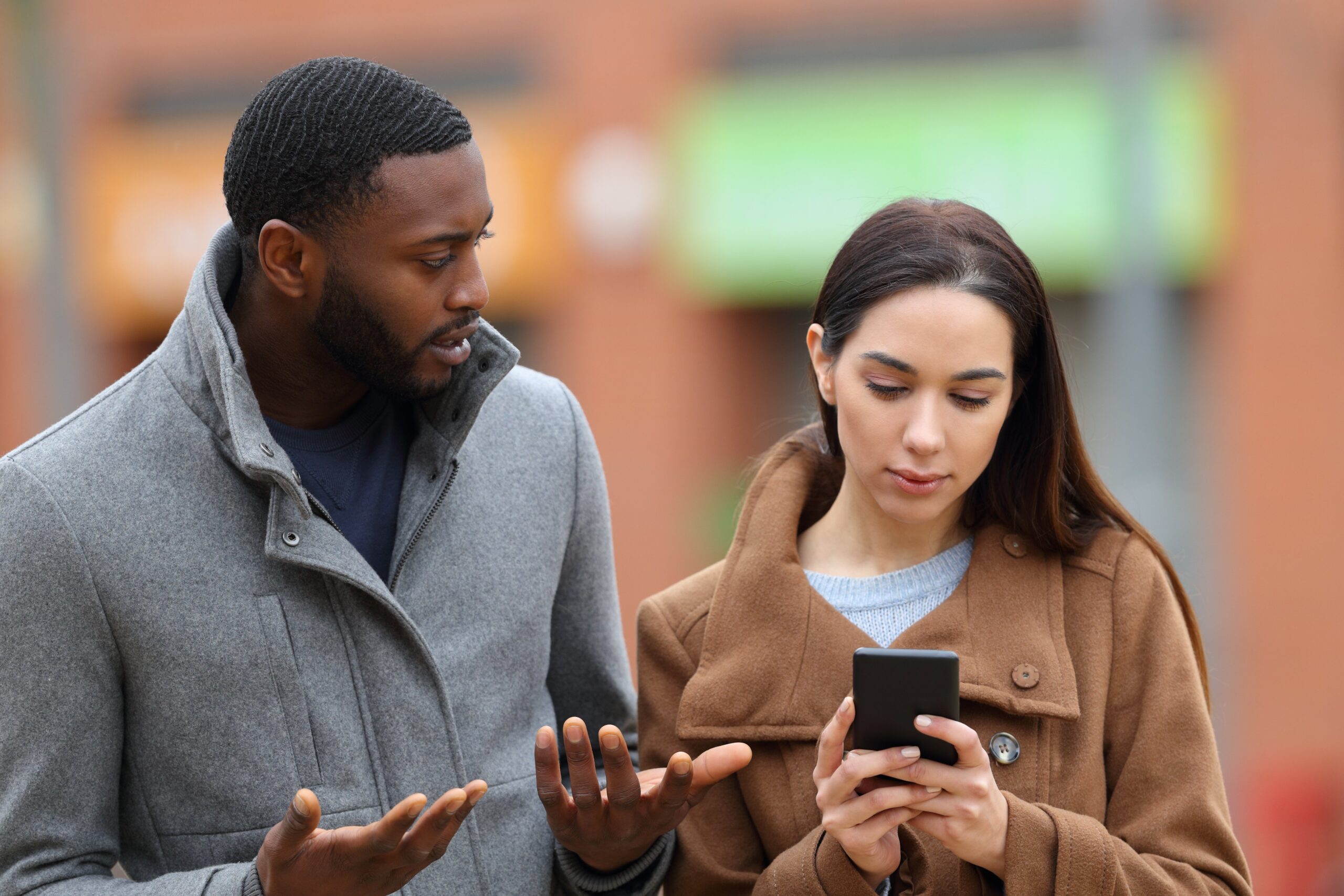 Woman ignoring friend, using phone. 