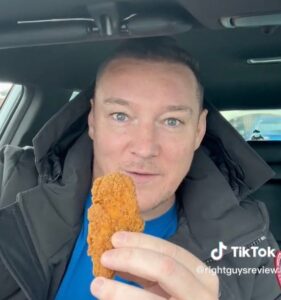 Man holding McDonald's chicken piece. 