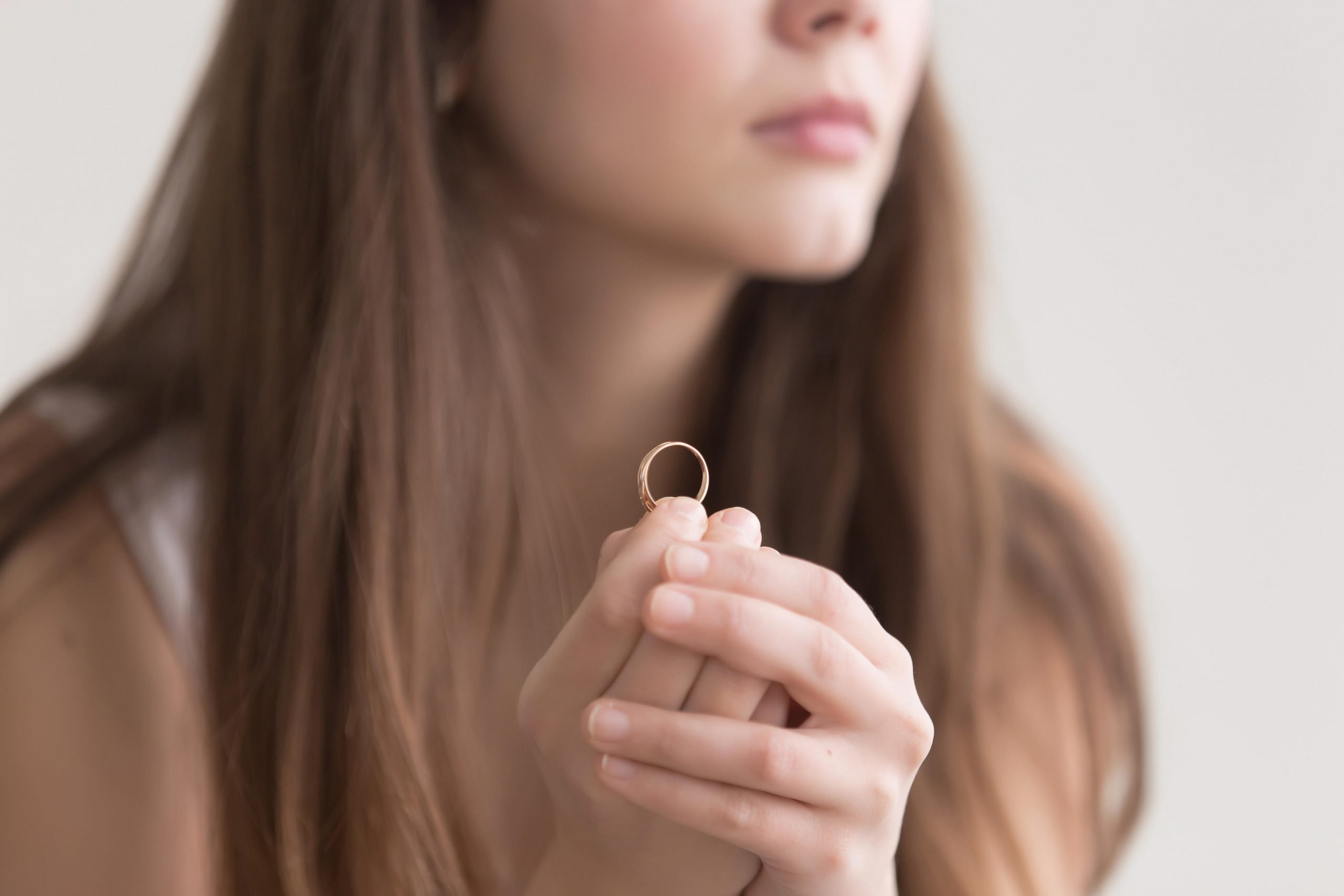 Woman holding wedding ring.