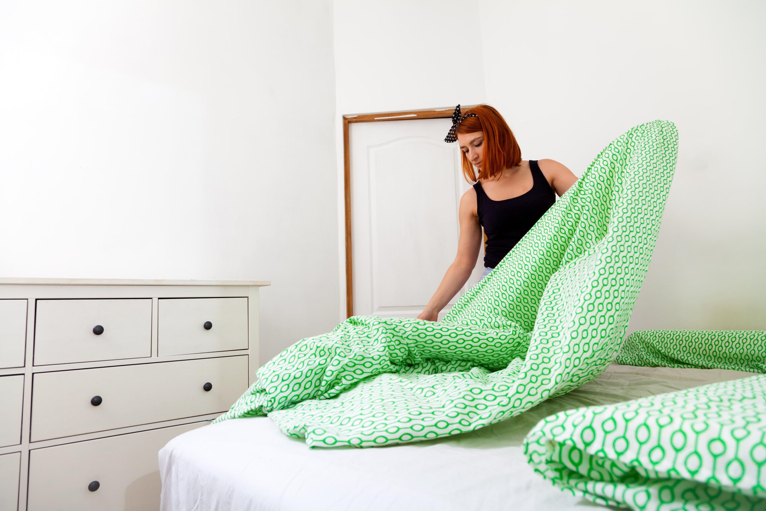 Woman changing bed sheet. 