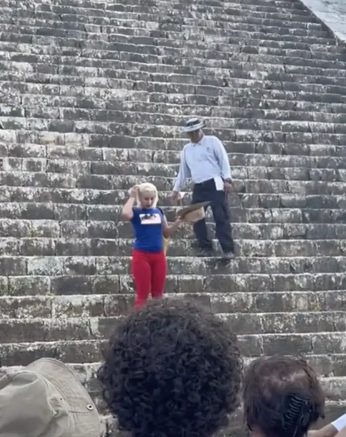 Woman climbs ancient pyramid. 