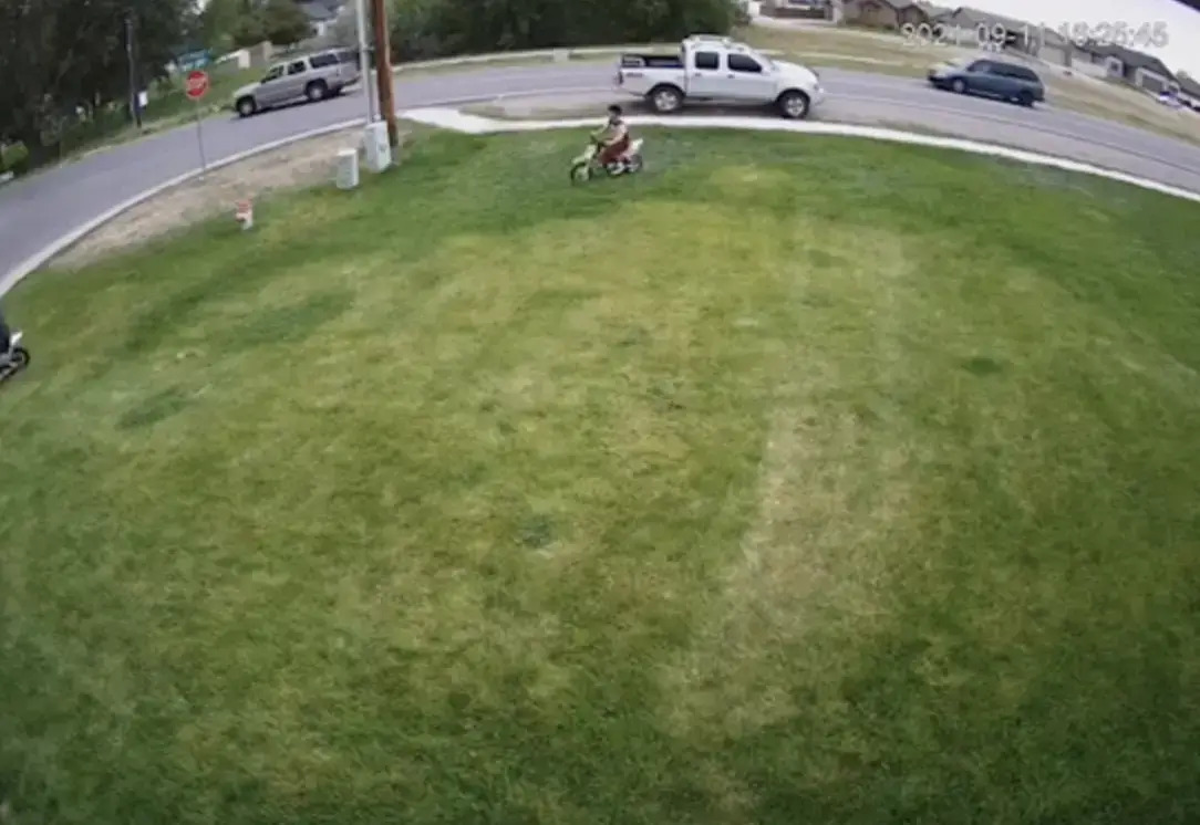 Person cycling across someone's lawn