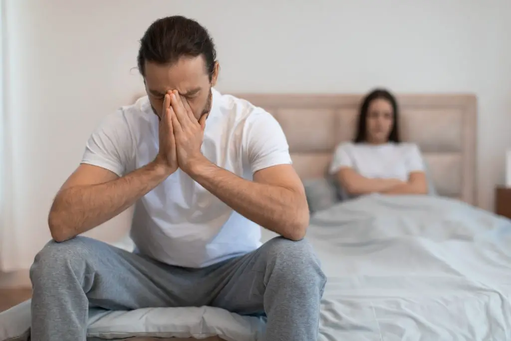 Man stressed in bedroom.