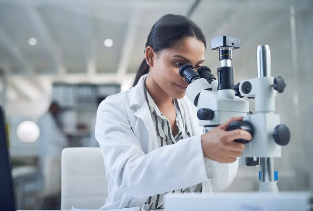 Woman looking into microscope.