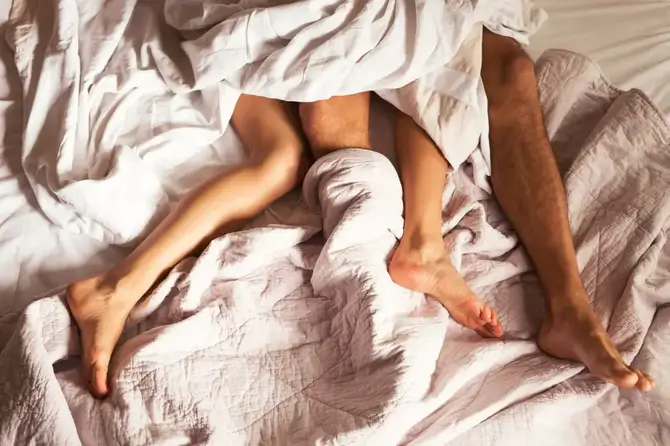 Couple's feet in bed