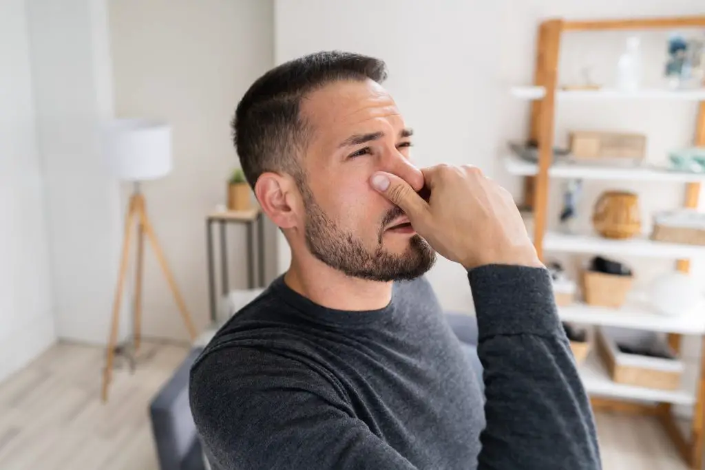 Man smelling bad odor.
