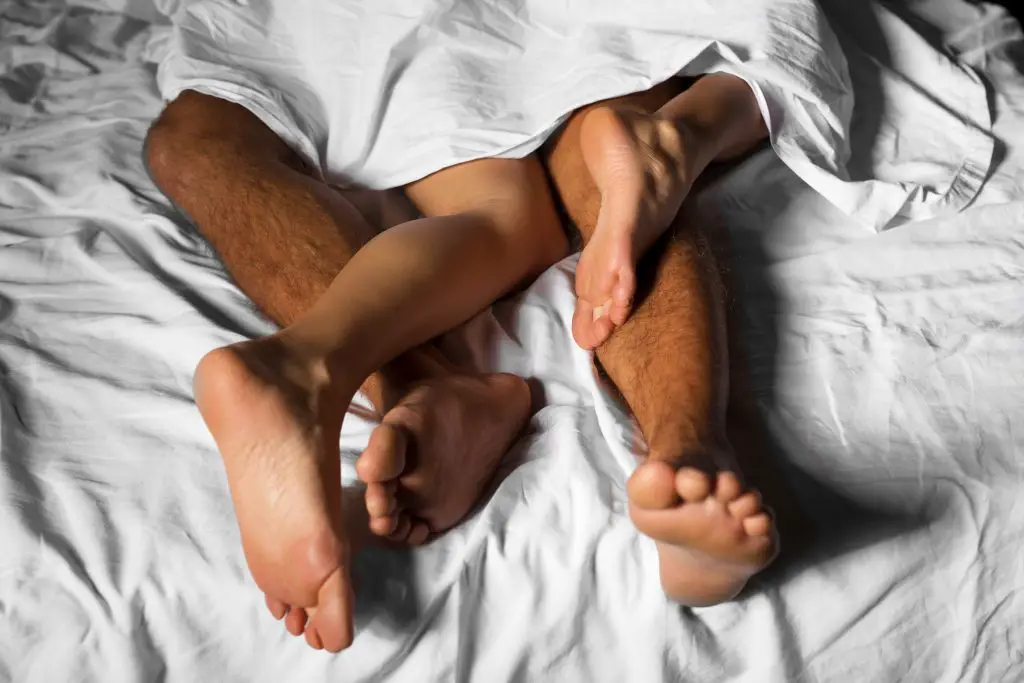 Couple's feet in bed.