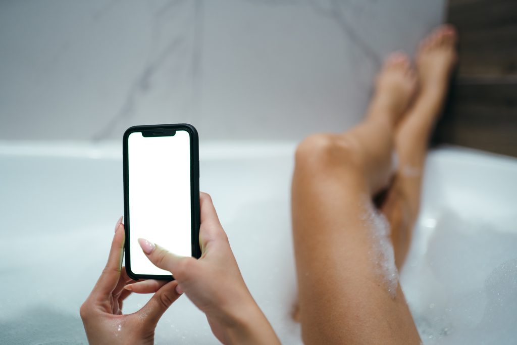 Woman Legs In Bath Using Phone